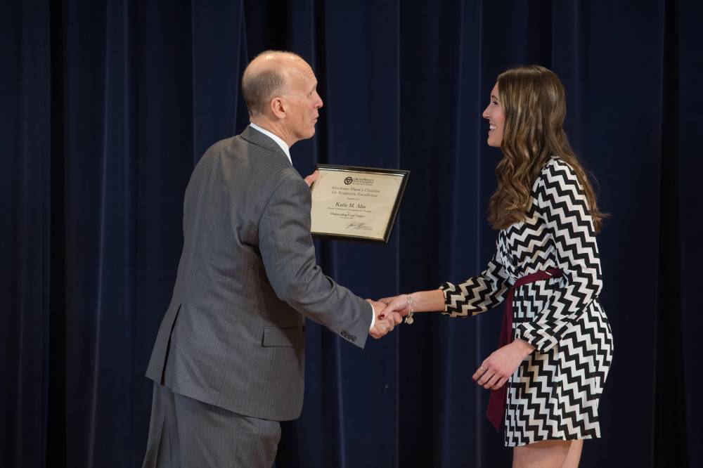 Graduate student receiving their award from Dean Potteiger